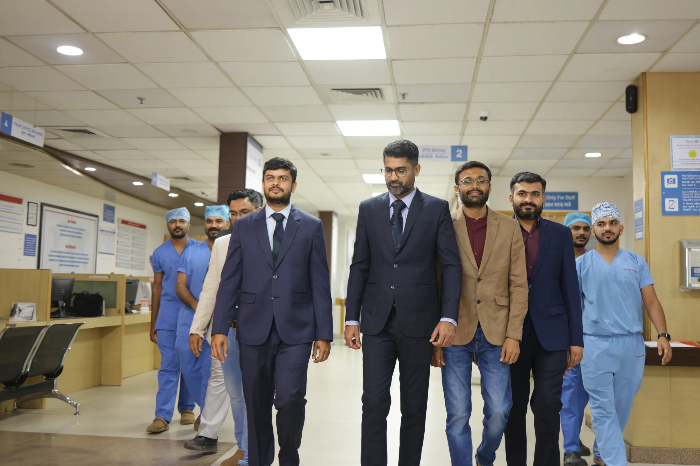 Consultants and theatre staff walking together through the hospital's outpatient corridor.