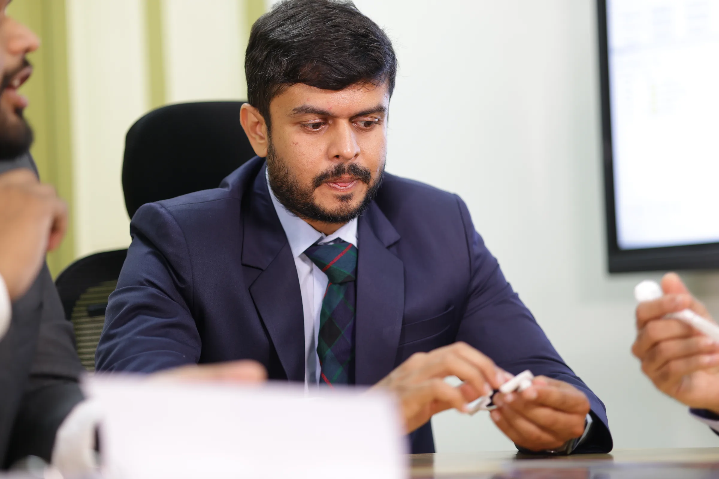 A cancer surgeon at the tumour board meeting, listening as a case is discussed.