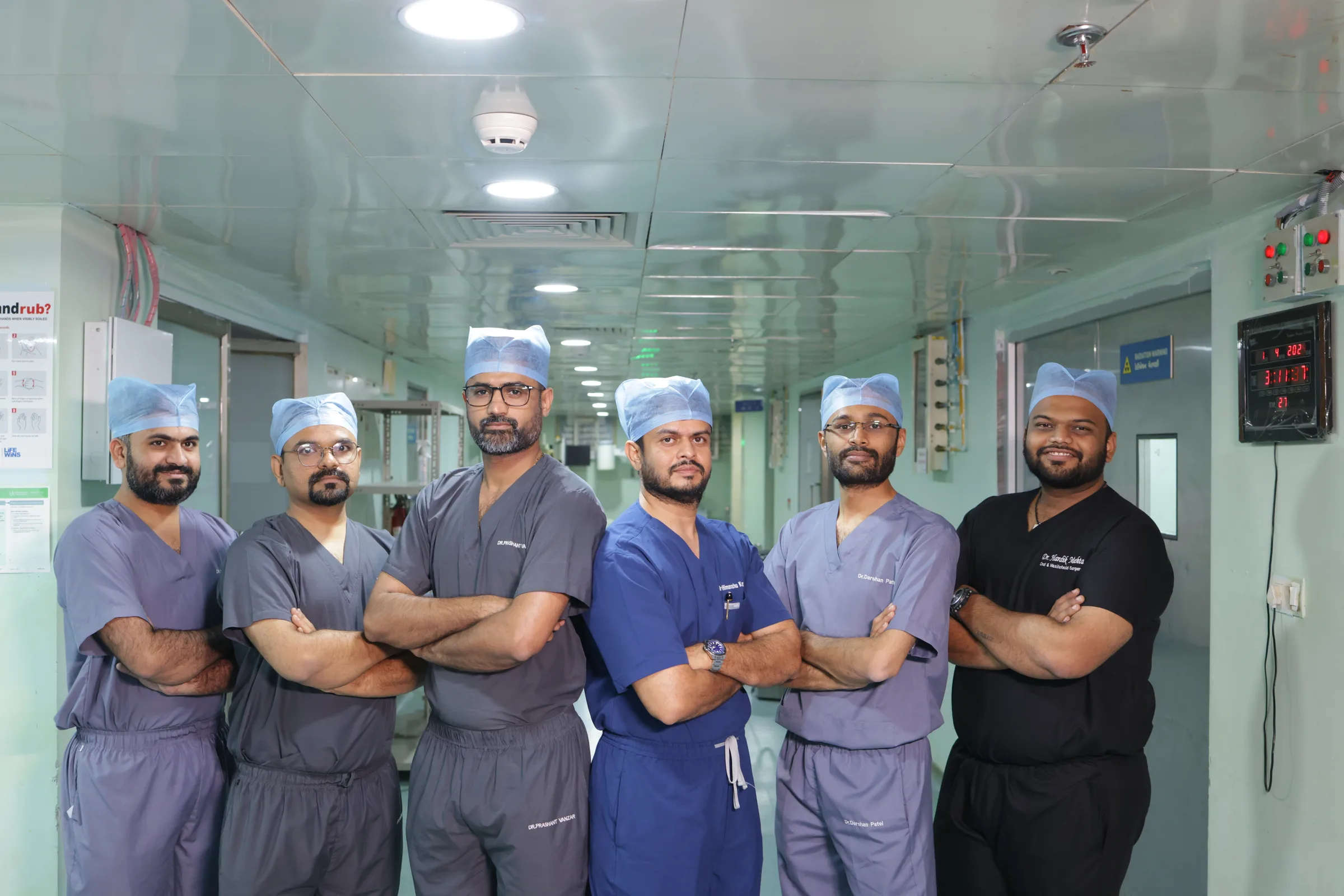 The operating theatre team at Rajkot in scrubs and caps, outside the theatre doors.