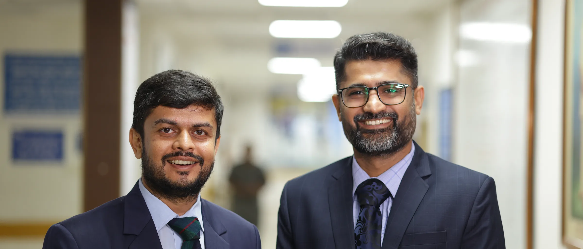Two of the practice's cancer surgeons standing together in the outpatient corridor.